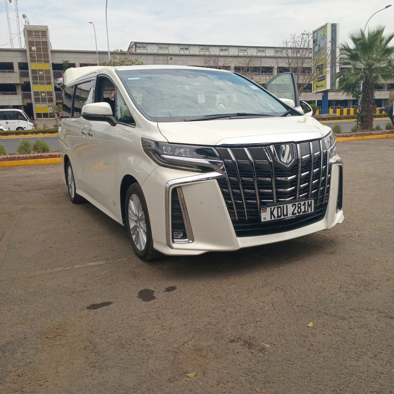 Front view of a white Toyota Alphard parked on a paved road